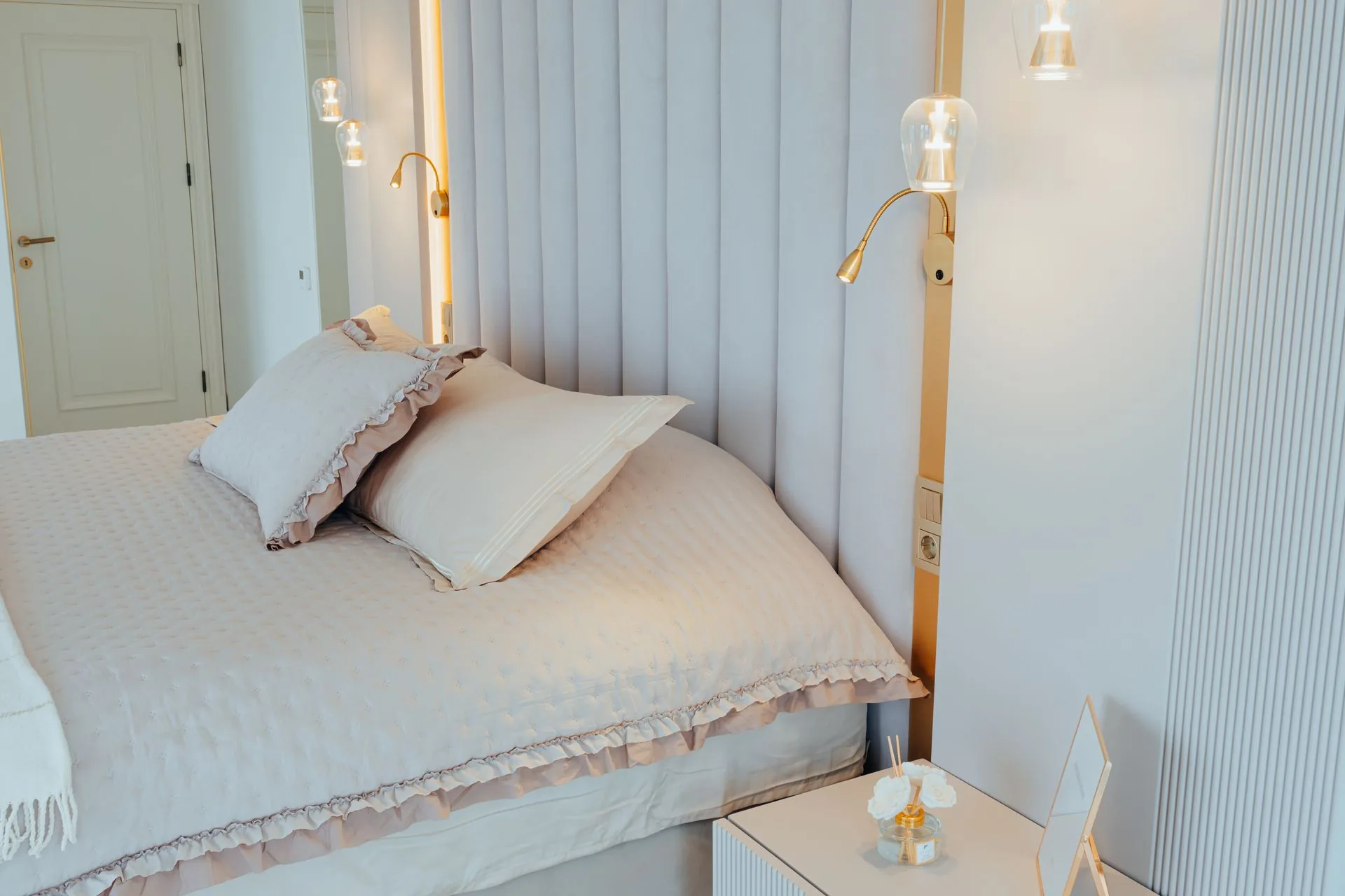 Premium Christmas gift scene: a bed with white organic bedding, a sleek air purifier and a countertop water filter in a sunlit room with a small Christmas tree