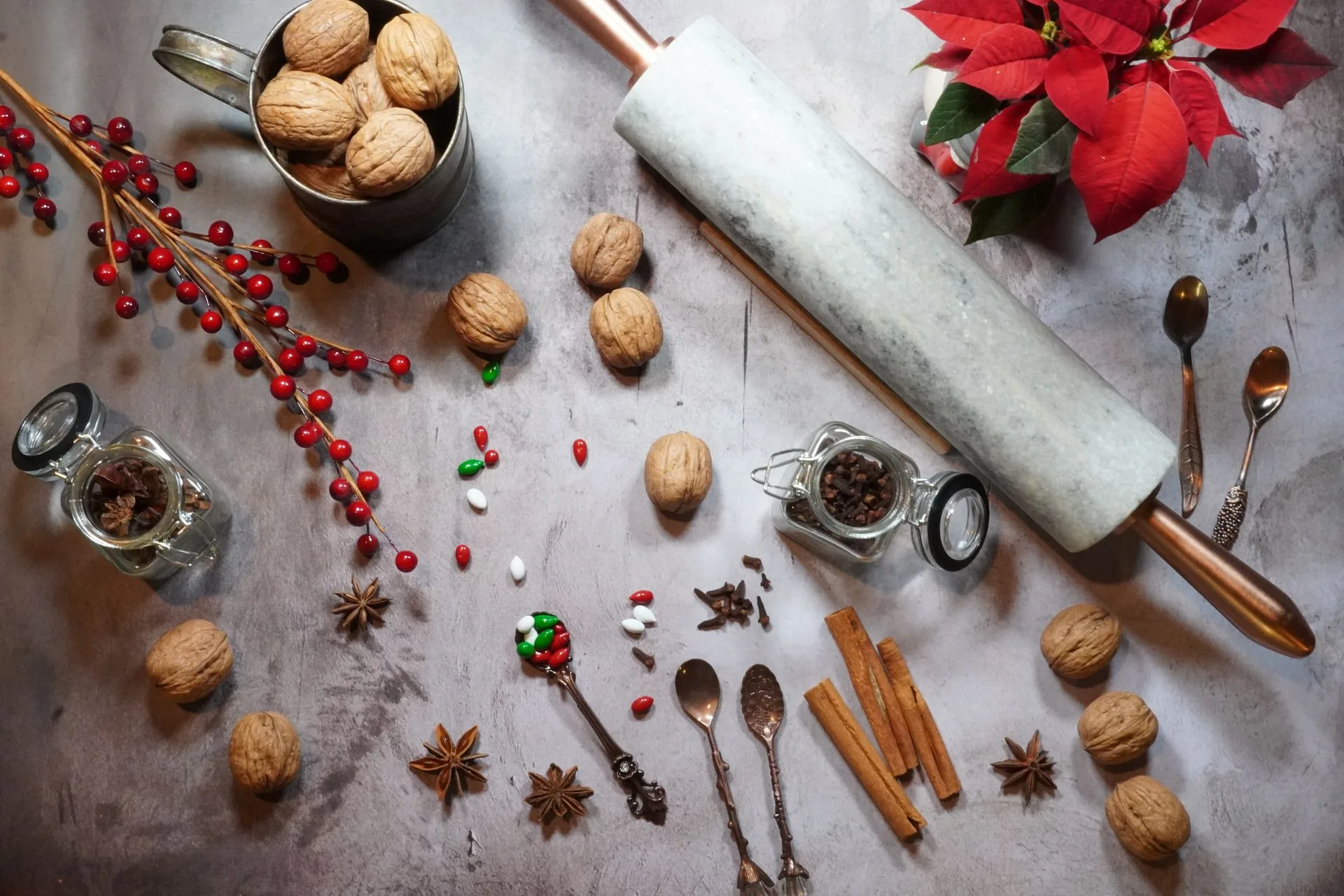 Christmas kitchen gifts on a counter: ceramic cookware, a cast iron skillet, wooden cutting boards, a glass pour-over coffee maker and a gooseneck kettle